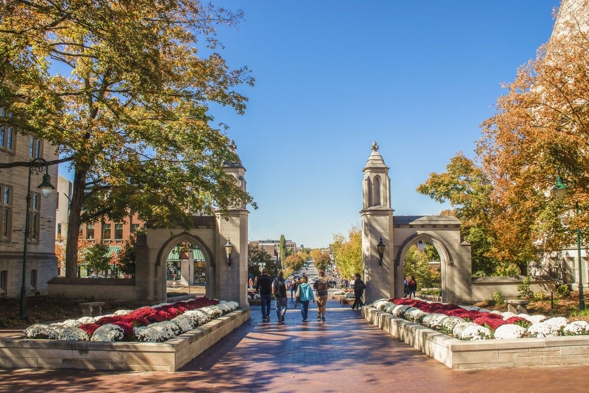 University of Indiana - Family walks with college student out main gates of campus down into the town during Fall Break weekend