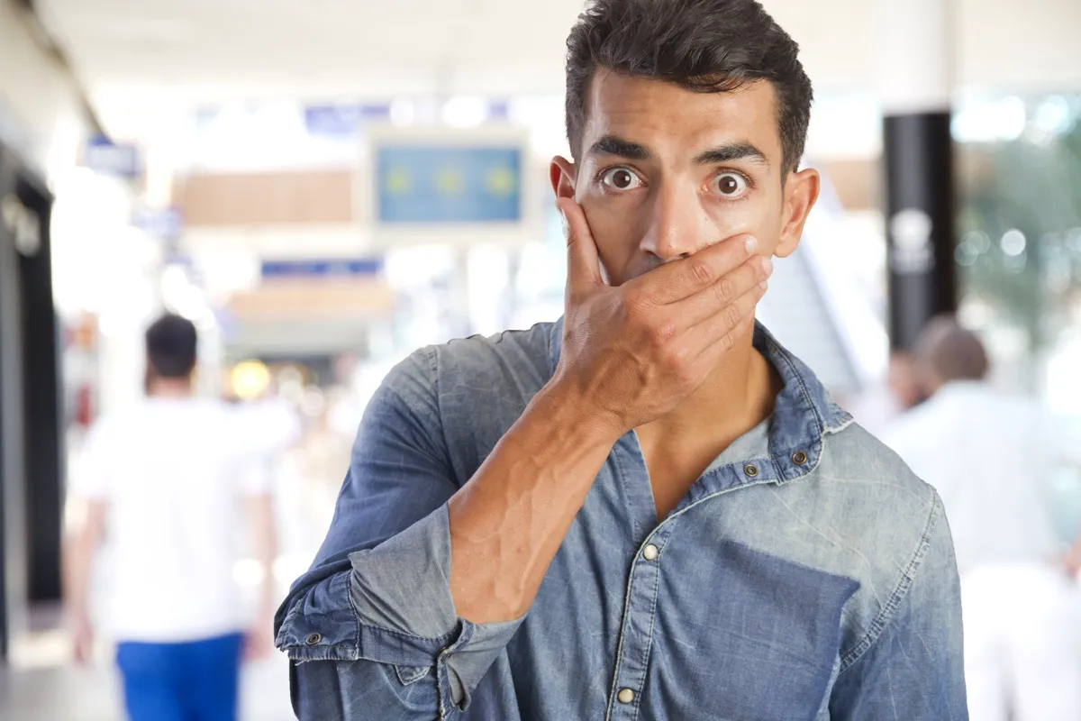 Man covering his mouth so he doesn't curse
