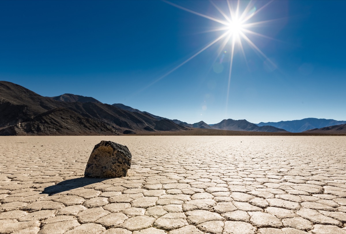A lone "sailing rock" sits basking in the bright unrelenting sun at Racetrack Playa in Death Valley National Park, California