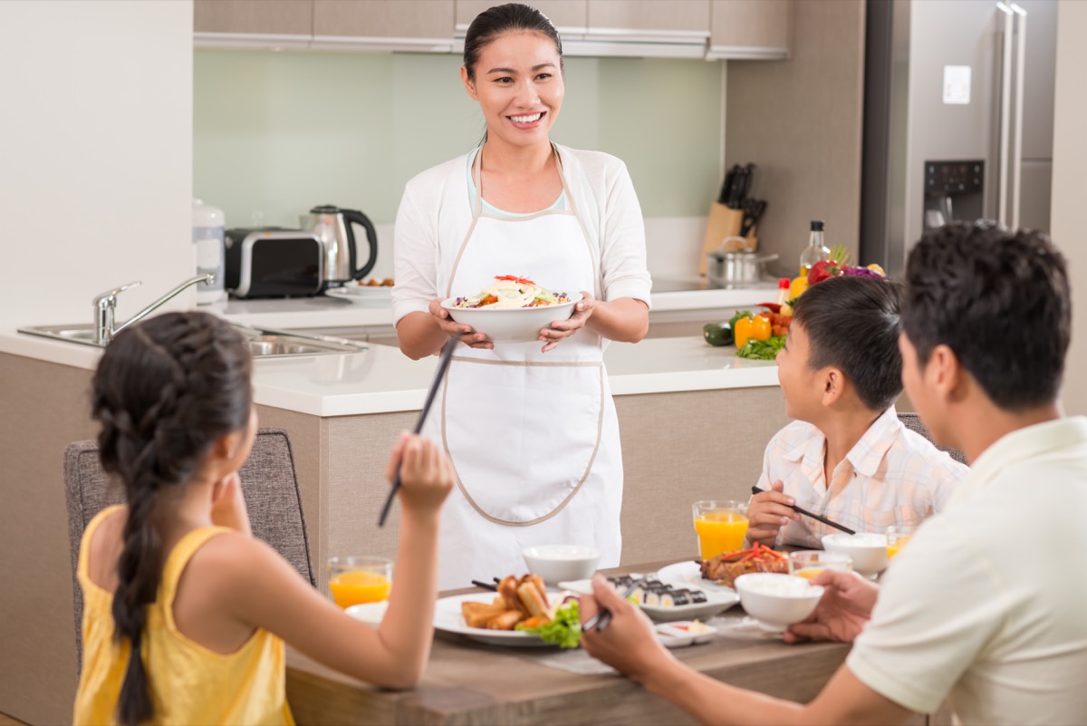 Mom serving dinner to her family in kitchen