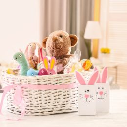 large white easter basket with pink bow on white table