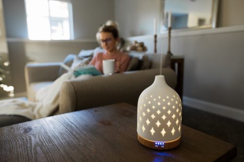 young woman working from home with essential oil diffuser