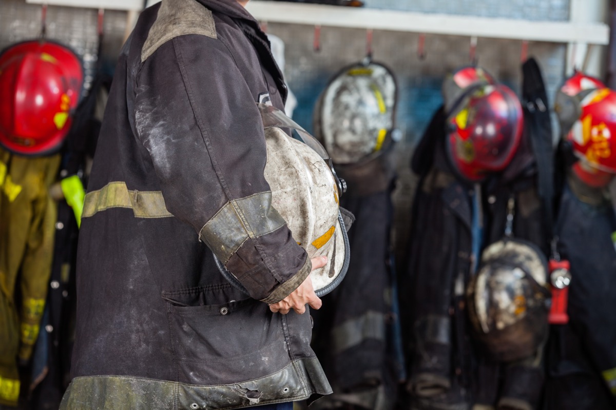 Firefighter in gear holding helmet