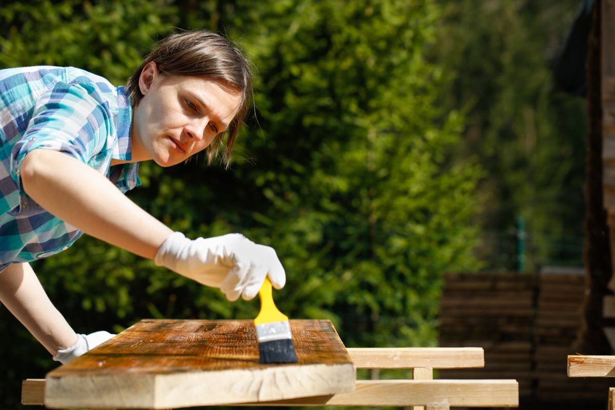 Woman glazing wood table