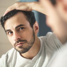 Man looking at his hair