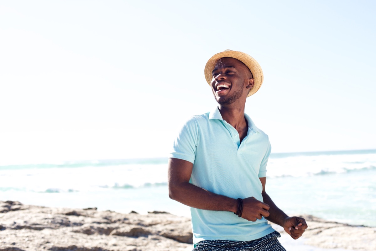 Happy man on the beach wearing a hat