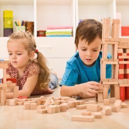 two young white kids playing with wooden blocks