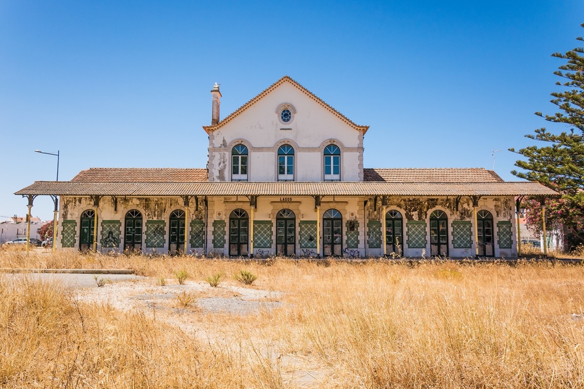 abandoned tile train station with a field in front