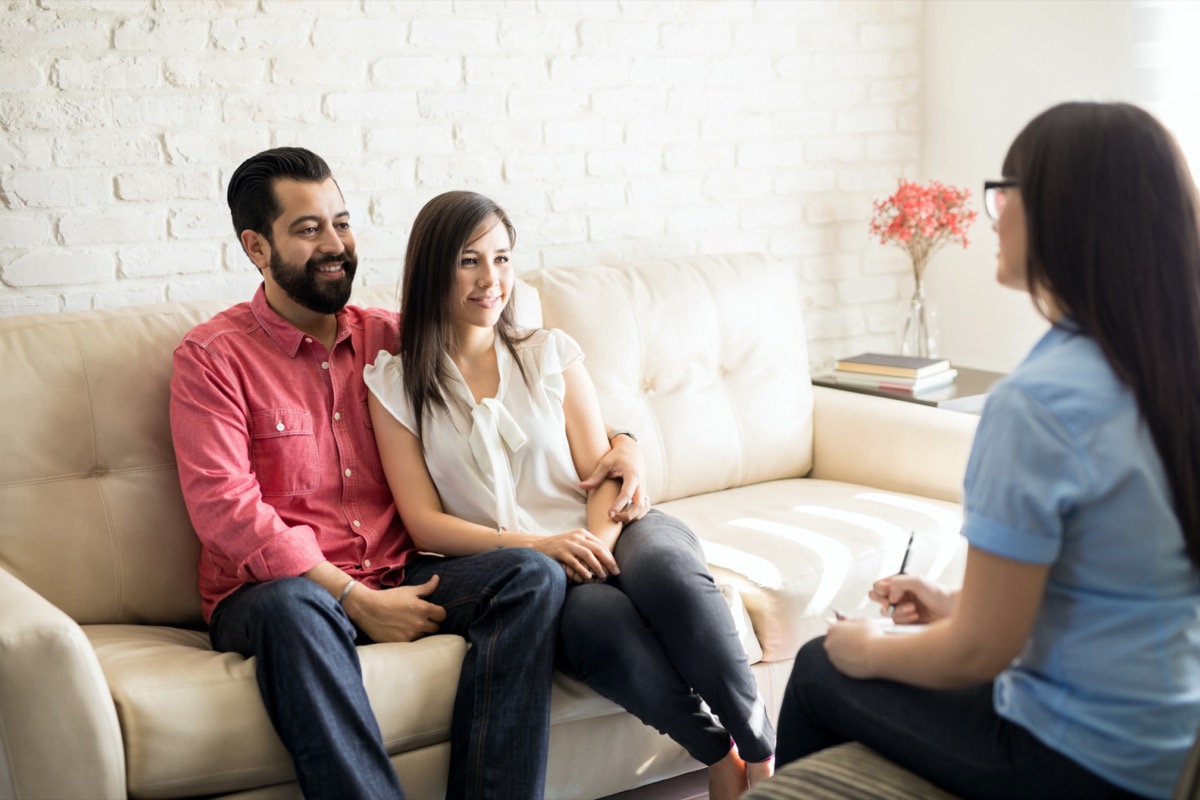 latinx man and woman smiling at female couples therapist
