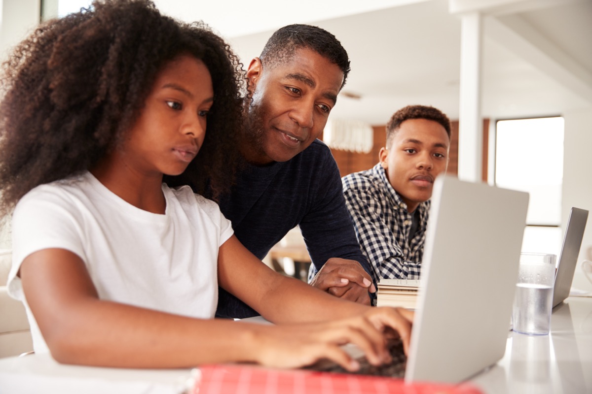 Dad helping children with homework and studying online