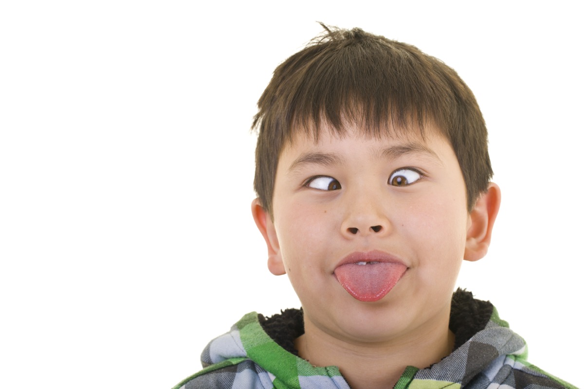 young asian boy crossing eyes and sticking out tongue