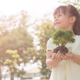 little girl holding plant oudoors