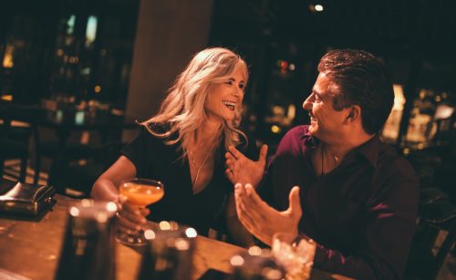 man flirting with older woman at the bar