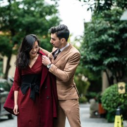 man helping woman put on her coat in the middle of the road