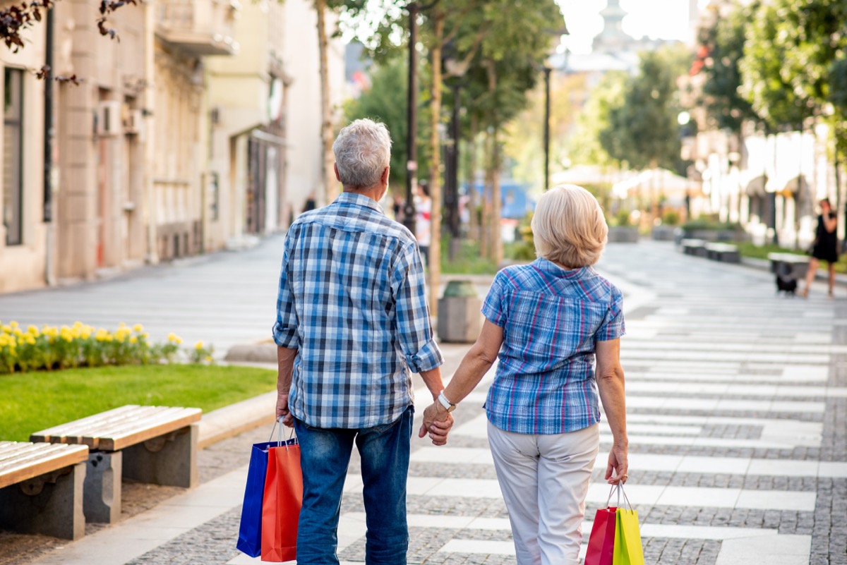 Older couple holding hands and shopping together