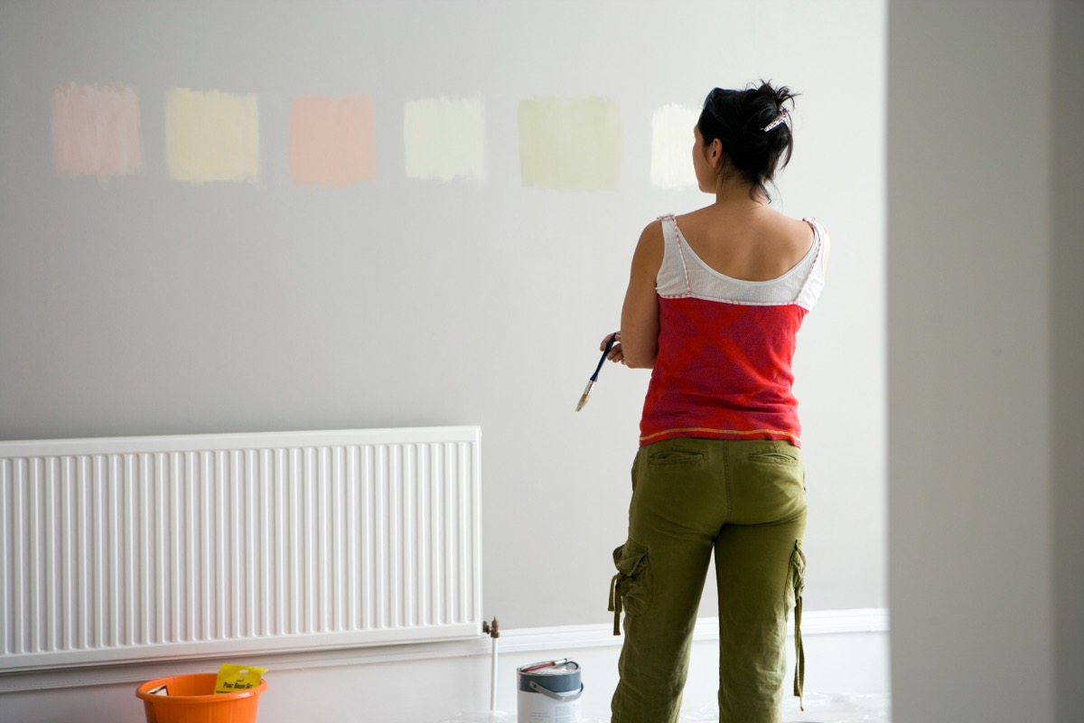 Woman trying to decide between paint colors on her wall