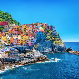 pastel colored buildings on a seaside cliff in italy