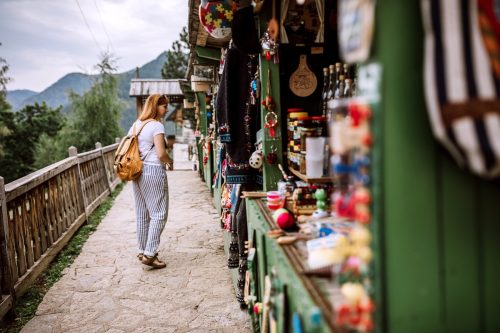 Eine junge Touristin sucht in ihrem Sommerurlaub auf dem Straßenmarkt nach Souvenirs