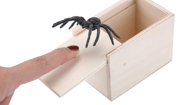 white hand and spider coming out of box