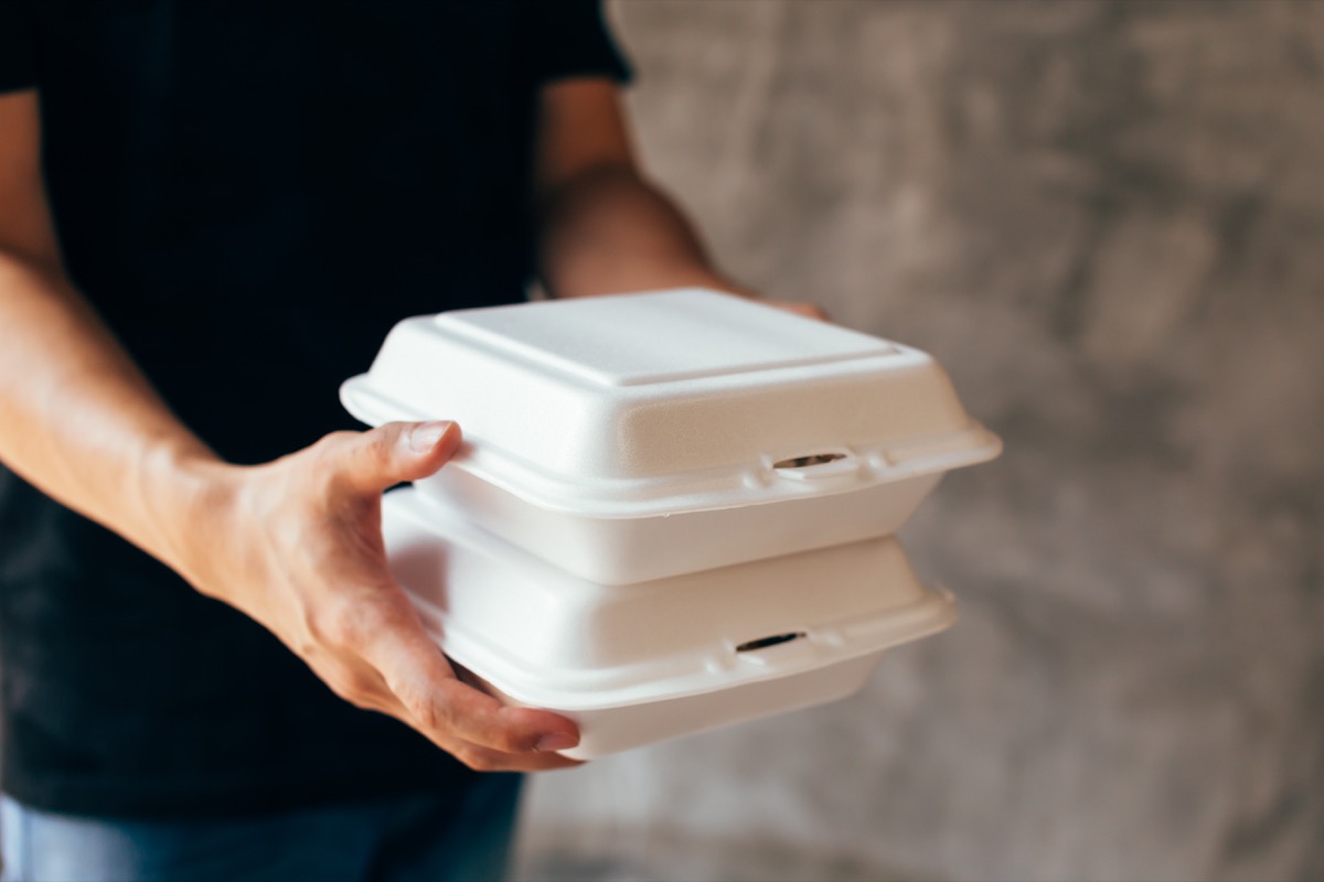 Close-up of delivery man handing a slack of foam lunch box - Foam box is toxic plastic waste. It can be used for recycling and environment saving concept