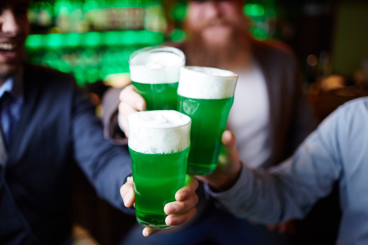 a group of men toasting green beer on st. patrick's day
