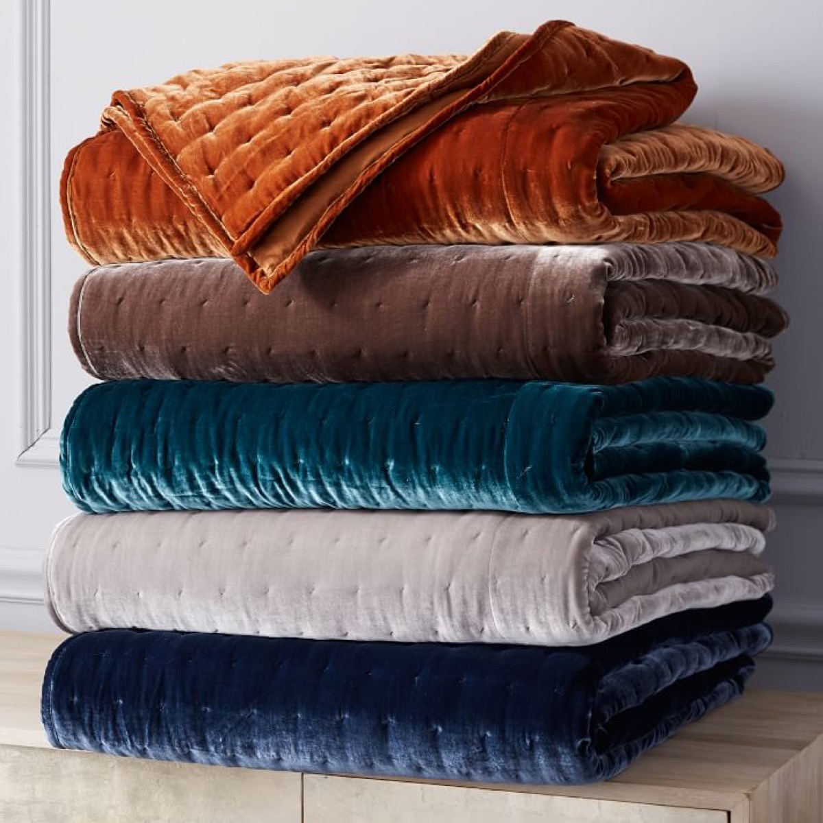 stack of velvet quilts and shams on sale at West Elm