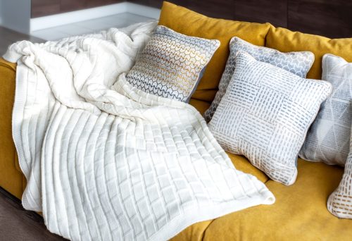 white blanket on yellow couch