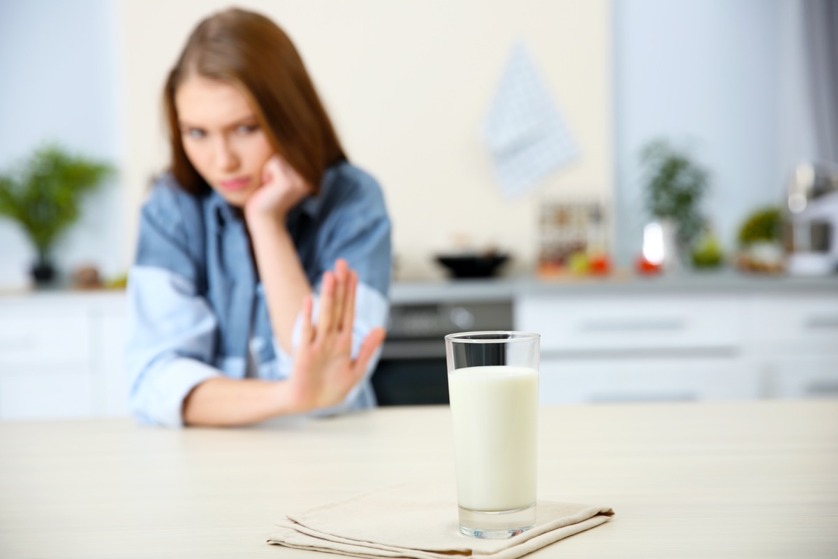 young white woman refusing glass of milk