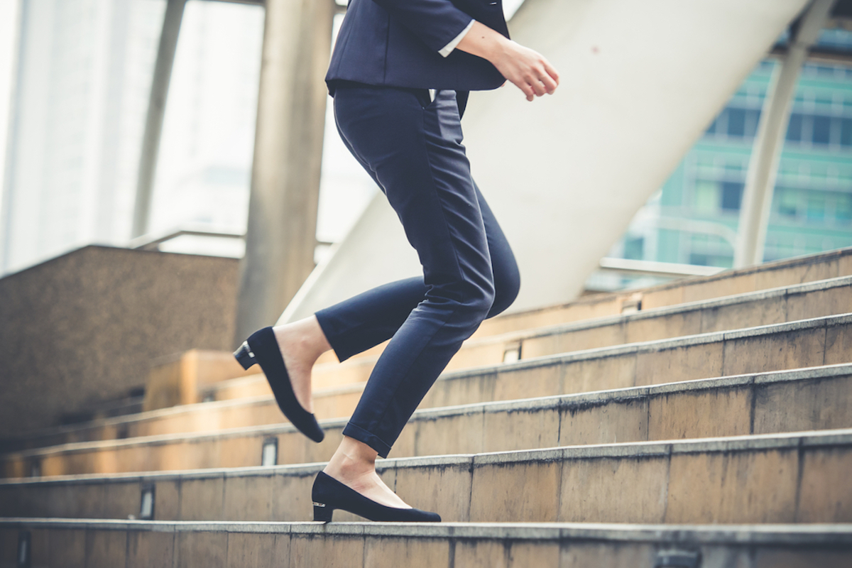 woman running up stairs to work