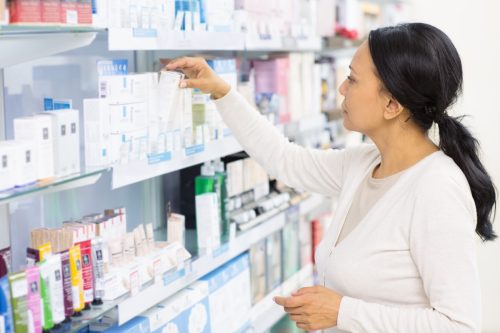 middle aged woman shopping at drugstore or pharmacy