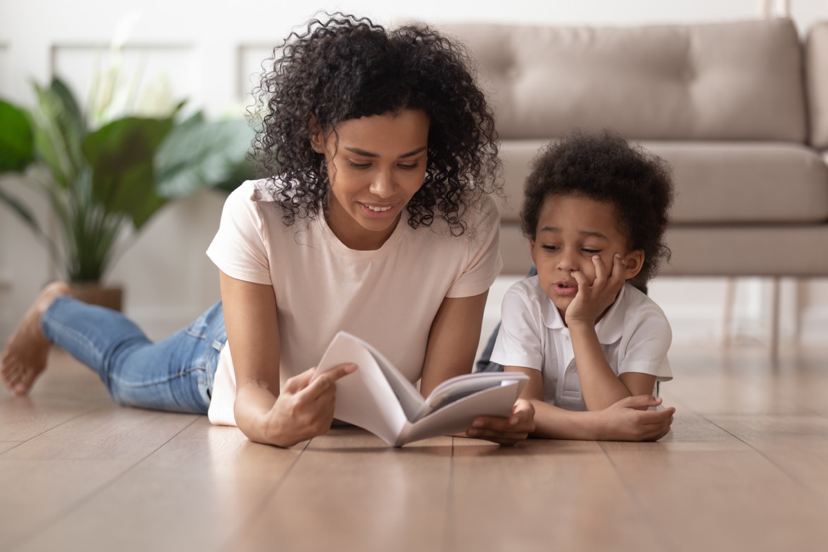 young black mother reading book to son