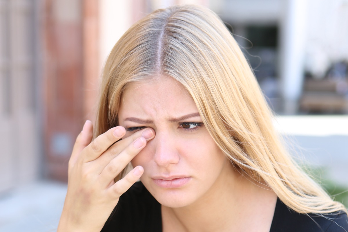 young blonde woman with eye pain