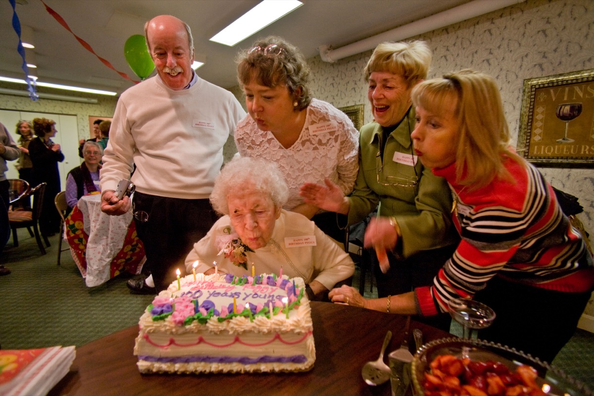 BC6W2A Assisted by family and friends a centenarian blows out the candles on her cake during her 100th birthday party. Image shot 2007. Exact date unknown.