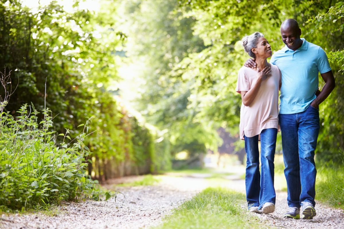 Older black couple walking down path