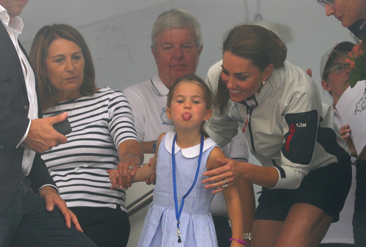 The Duchess of Cambridge with Princess Charlotte and Carole Middleton (left) look through a window at the prize giving after the King's Cup regatta at Cowes on the Isle of Wight.