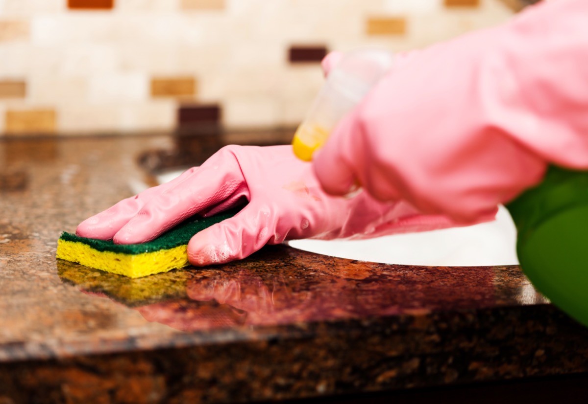Woman cleaning counter top in the kitchen