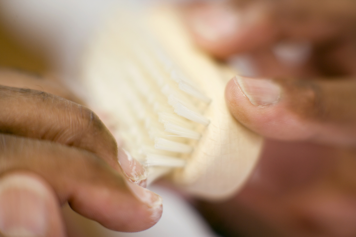closeup of hands cleaning under nails with a brush