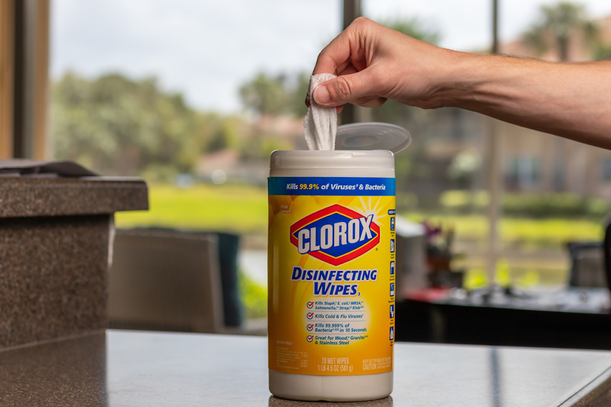 hand grabs clorox wipe from bottle on counter
