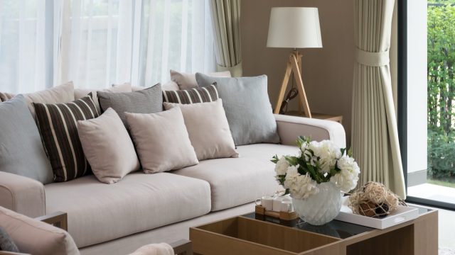 crowded living room with beige sofa