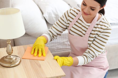 Woman dusting side table