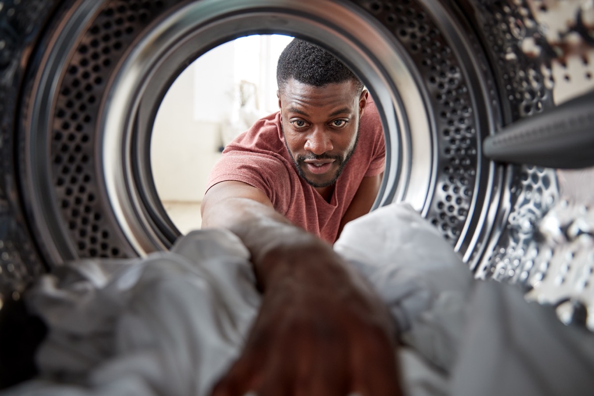 Watch looking out from inside the washing machine as the man washes the white clothes