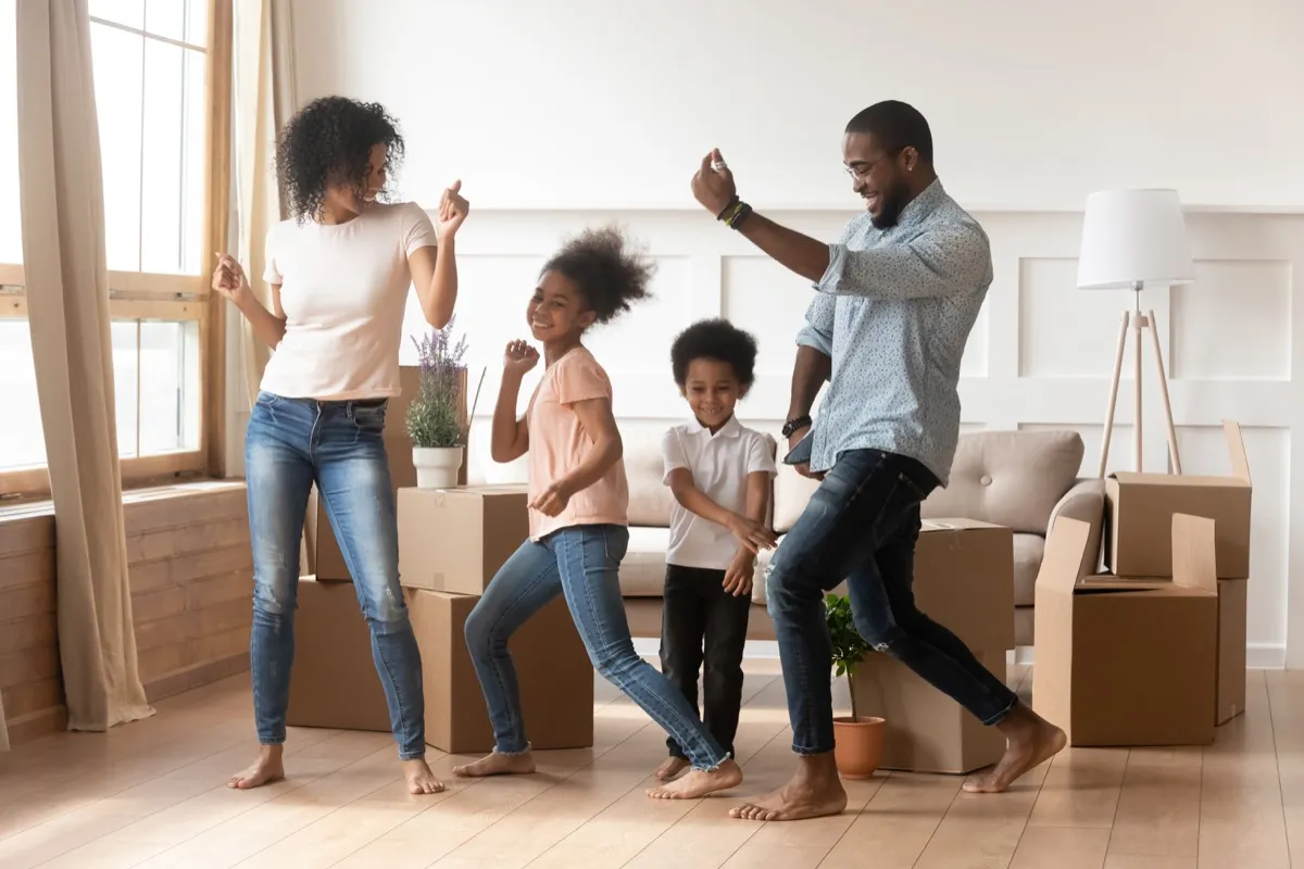 young black family dancing in living room