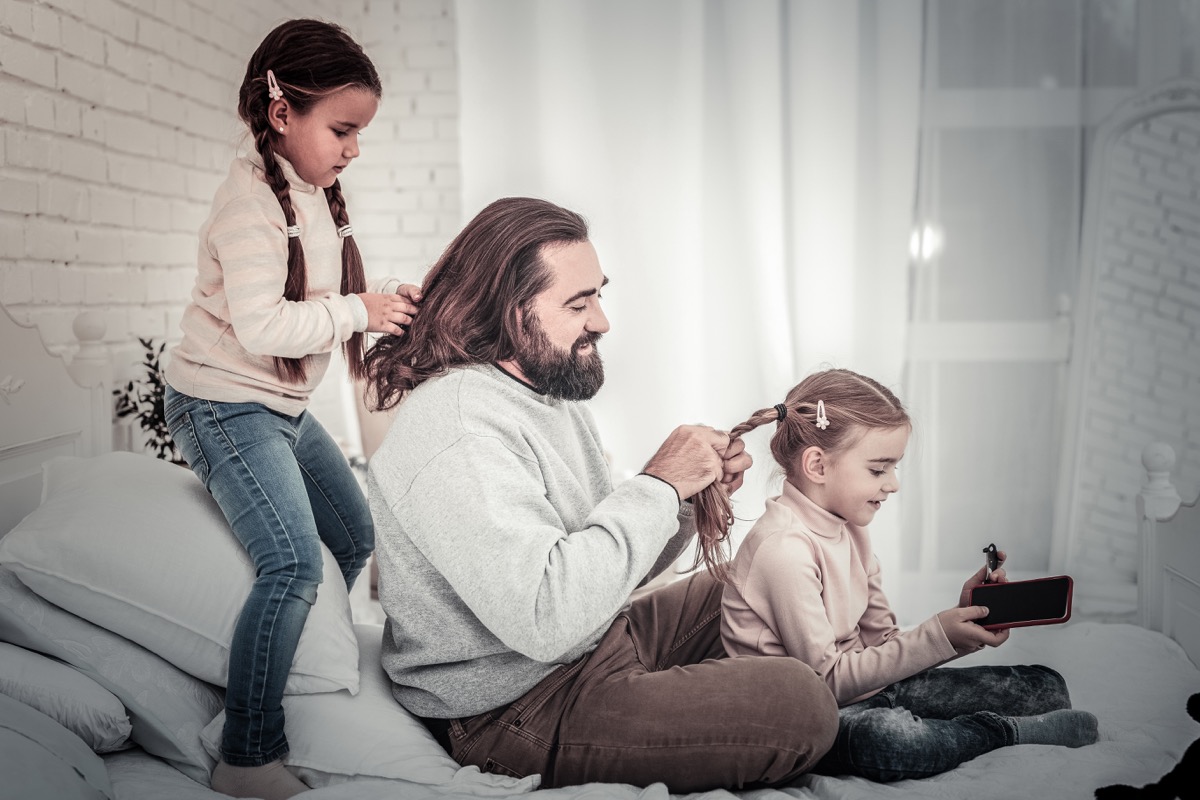 father braiding daughter's hair
