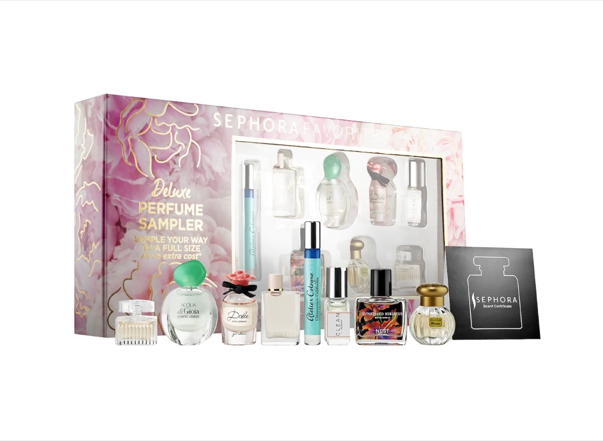eight mini bottles of perfume and a gift certificate in front of a floral gift box