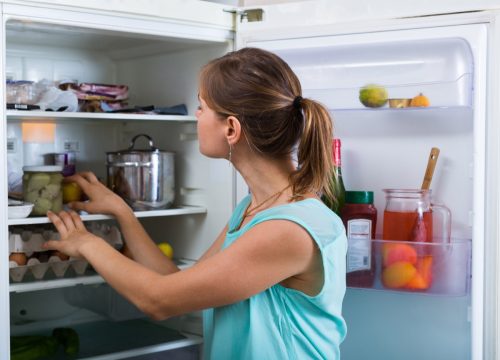 Woman going through fridge