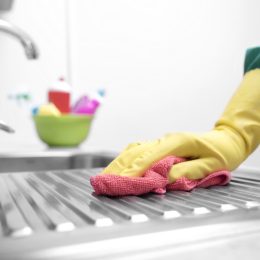 hand in yellow gloves cleaning kitchen