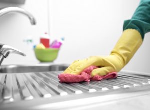 hand in yellow gloves cleaning kitchen