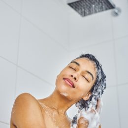 woman washing her hair in shower with shampoo