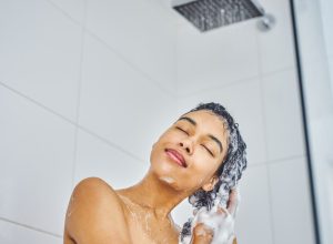 woman washing her hair in shower with shampoo