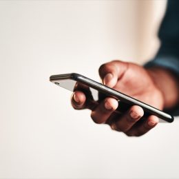 Cropped shot of an unrecognizable businessman standing alone in his home office and texting on his cellphone